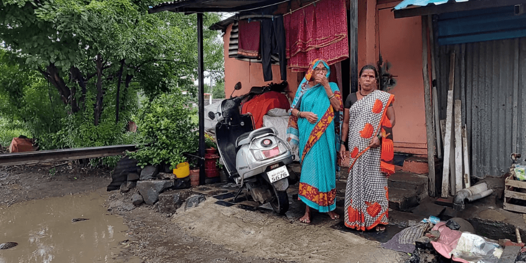 [domestic work] Two women who do domestic work standing in front of their home