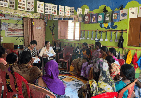 Women sitting in a circle inside a classroom