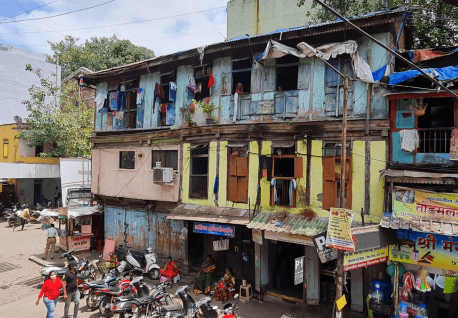 Old kaccha houses with small windows and women peering out