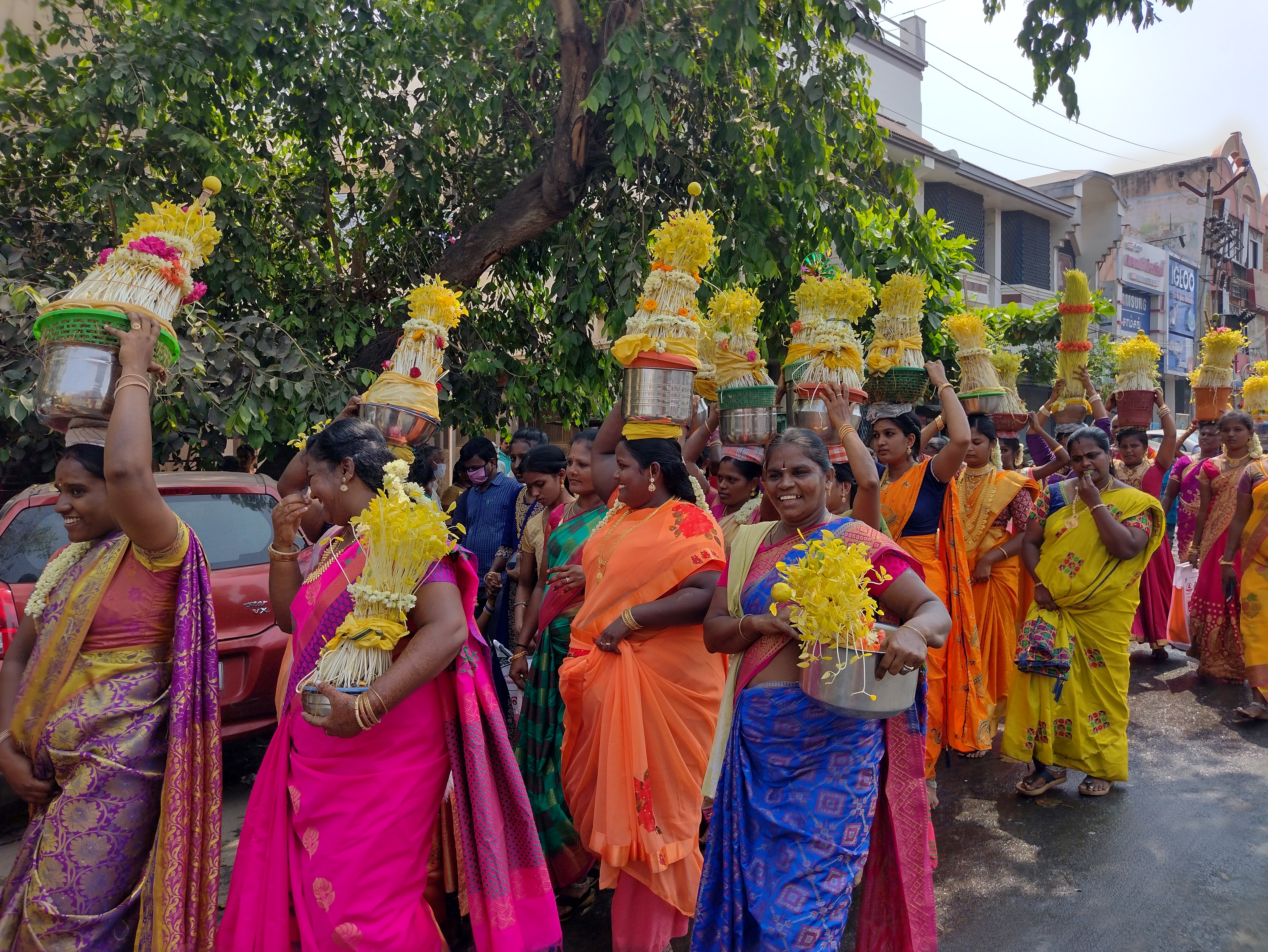 Women laughing and smiling with flower pots over their heads